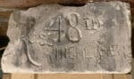 Name of Ross, 15th Battalion, carved in  stone wall of house during WWI